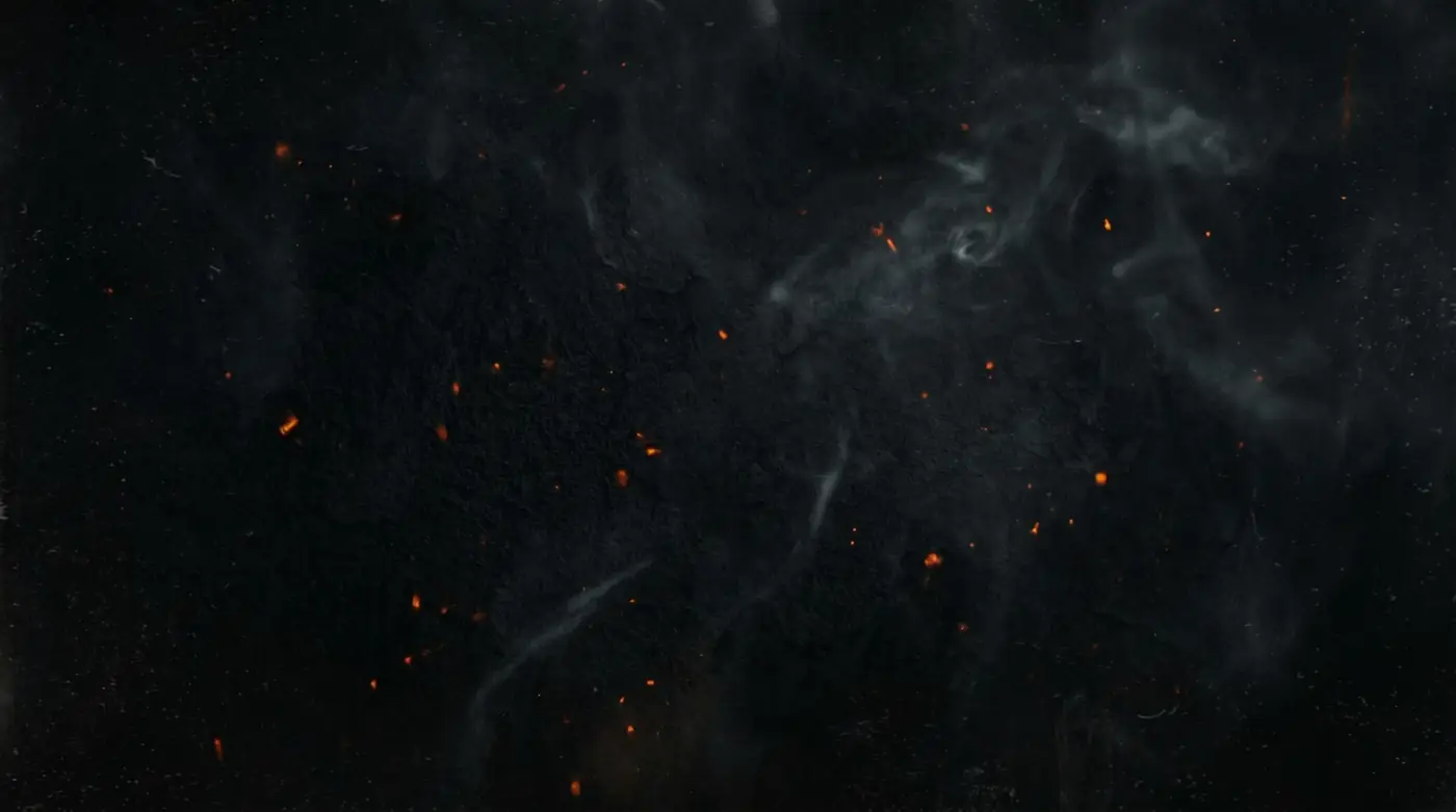 Embers glowing in a dark roasting pit